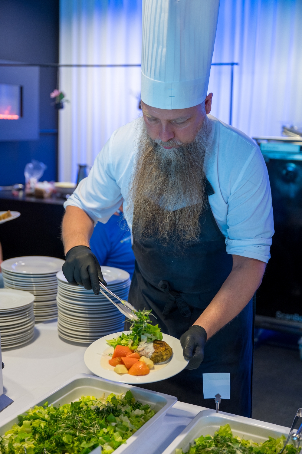 En kock lägger upp mat på en tallrik